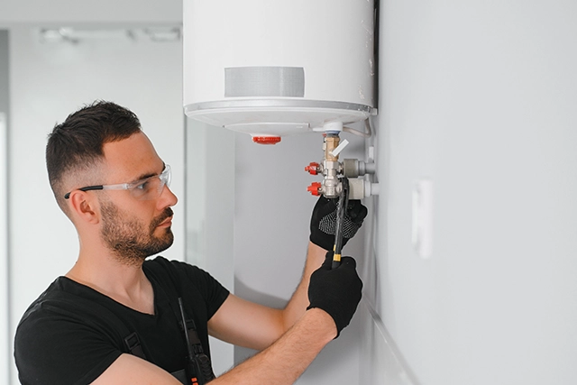 Technician Installing a Tankless Water Heater on a White Wall