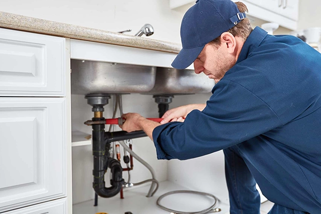 Plumber Fixing Kitchen Sink Pipes for Residential Plumbing Service